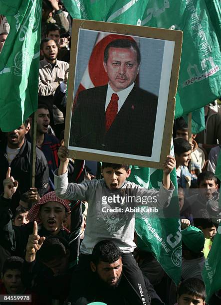 Palestinian holds a portrait of Turkish Prime Minister Recep Tayyip Erdogan as he shouts anti-Israeli slogans during a demonstration outside the...
