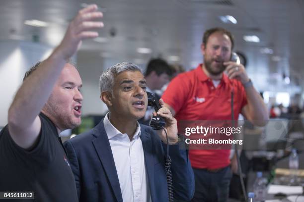 Sadiq Khan, mayor of London, center, speaks on a fixed line telephone on the trading floor during a charity day at BGC Brokers L.P., a unit of BGC...
