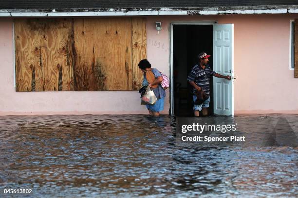 Couple leave their flooded home the morning after Hurricane Irma swept through the area on September 11, 2017 in Bonita Springs, Florida. Hurricane...