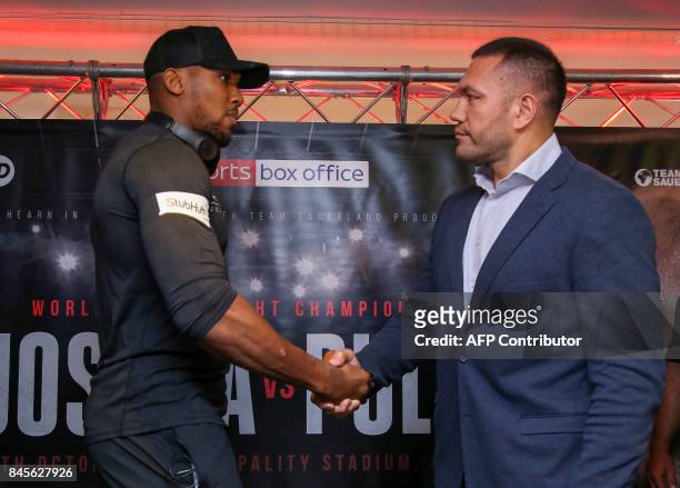 Britain's Anthony Joshua and Bulgaria's Kubrat Pulev shake hands during a press conference at the Principality Stadium in Cardiff on September 11,...