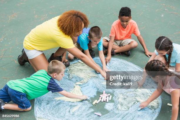 conseiller de camp avec les enfants, craie, dessin de terre - animateur photos et images de collection