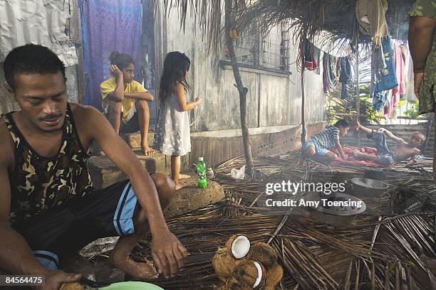 The Sauaki family prepares to cook their Sunday meal in an 'umu April 08, 2007 on the island of Felemea, in the Ha'apai island group of Tonga. The...