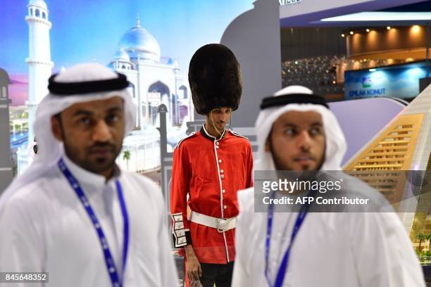Visitors walk past a model dressed up as a British soldier during the Cityscape Global exhibition, Dubai's premier property show, on September 11,...