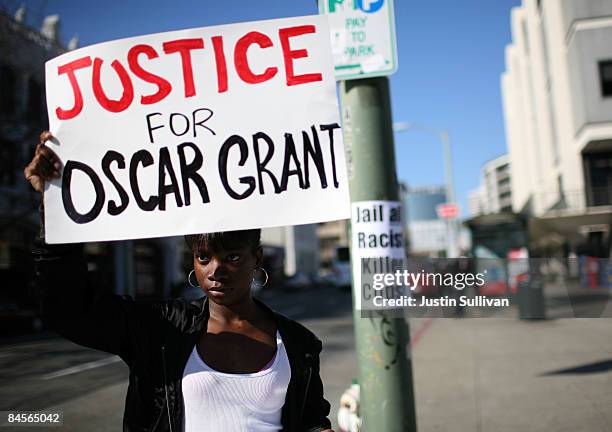 Javone Sloan holds a sign saying "Justice For Oscar Grant" during a protest of court case involving a Bay Area transit officer outside of the Alameda...