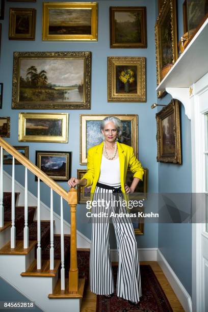 elegant woman in a fashionable outfit with grey hair standing in a staircase with oil paintings on the wall. - glamour photos stock pictures, royalty-free photos & images