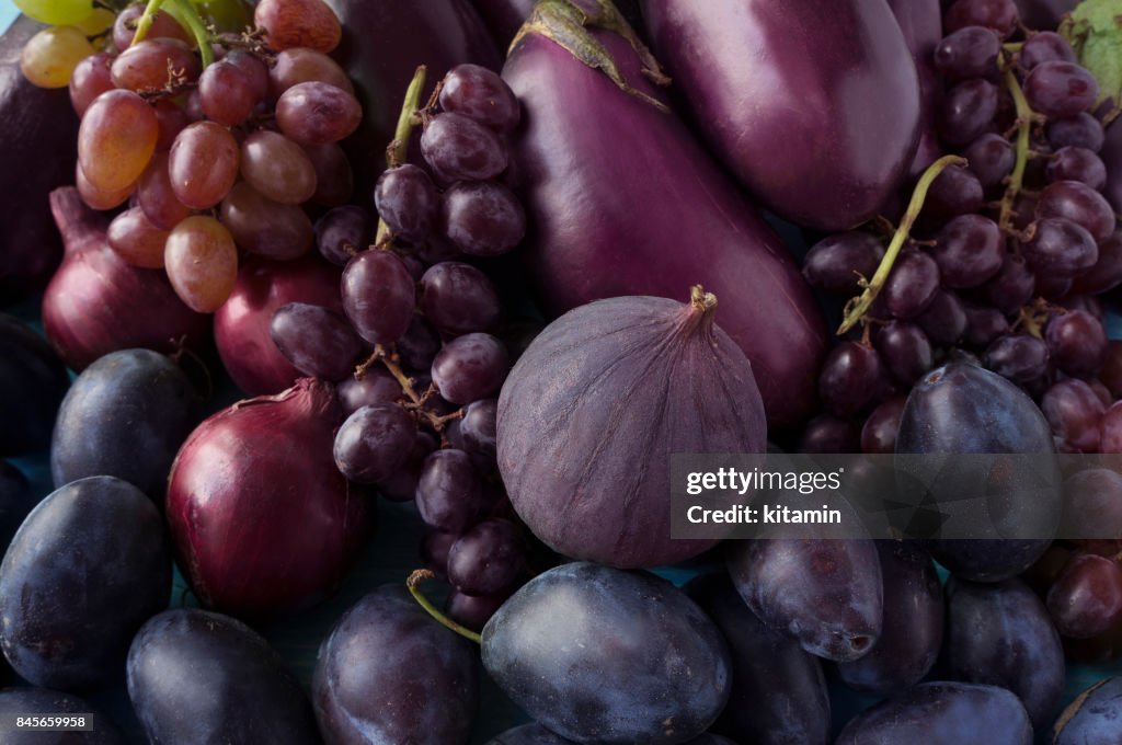 Aliments bleu et violet. Fond de fruits et légumes.  Figues fraîches, prunes, oignons, aubergines et raisins. Vue de dessus.
