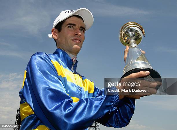 Jockey Steven Arnold poses with the winners trophy after riding Scenic Blast to win the Coolmore Lightning Stakes during the Coolmore Lightning...