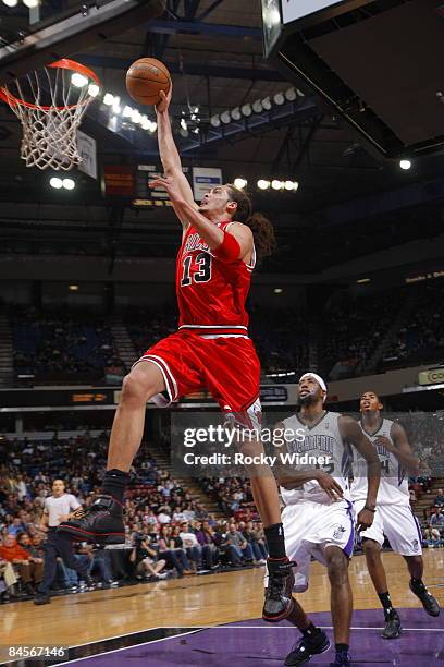 Joakim Noah of the Chicago Bulls takes the ball to the basket against John Salmons and Jason Thompson of the Sacramento Kings on January 30, 2009 at...