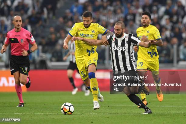 Gonzalo Higuain of Juventus is challenged by Alessandro Gamberini of AC Chievo Verona during the Serie A match between Juventus and AC Chievo Verona...