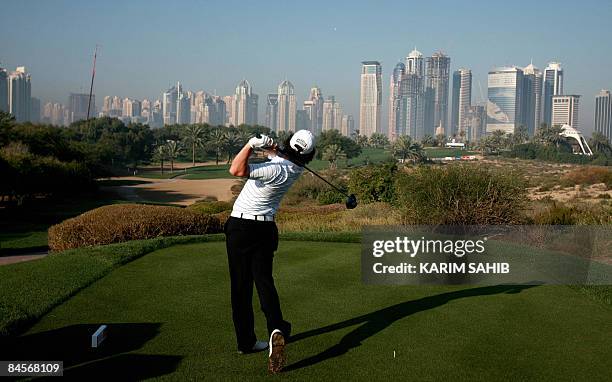 Ireland's Rory McIlroy plays a tee shot on the 8th hole during the third day of the Dubai Desert Classic golf tournament in the Gulf emirate on...