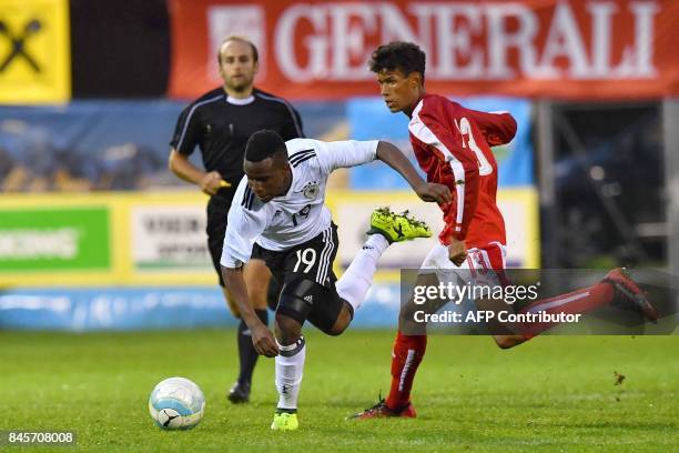 Germany's 12-year-old Youssoufa Moukoko and Austria's Simon Nosa Nelson vie for the ball during the friendly U16 football match between Austria and...