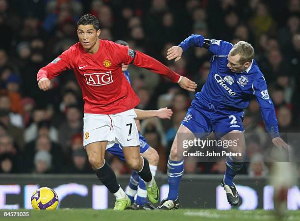 Cristiano Ronaldo of Manchester United clashes with Tony Hibbert of Everton during the Barclays Premier League match between Manchester United and...