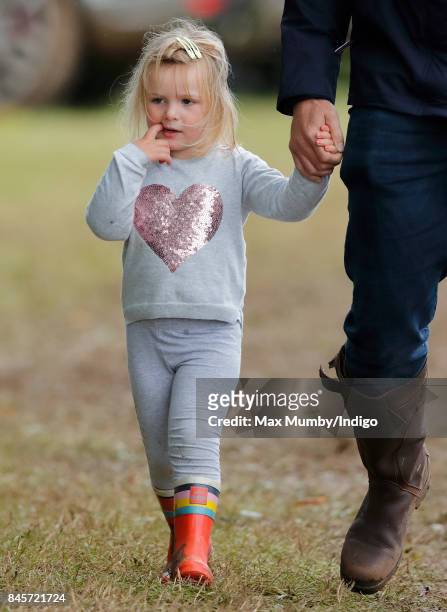 Mia Tindall holds hands with her father Mike Tindall as they attend day 3 of the Whatley Manor Horse Trials at Gatcombe Park on September 10, 2017 in...