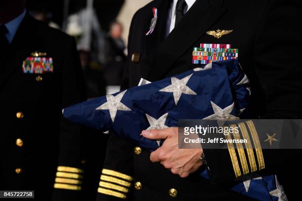 Navy Captain William Sherrod holds a flag from the USS Somerset to present to family members of the the victims at the Flight 93 National Memorial on...