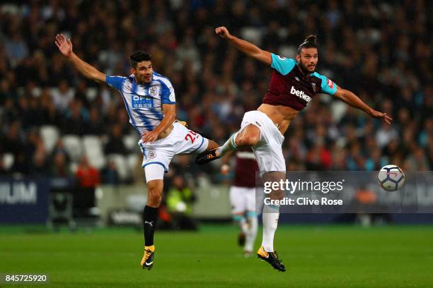 Christopher Schindler of Huddersfield Town and Andy Carroll of West Ham United jump for the ball during the Premier League match between West Ham...