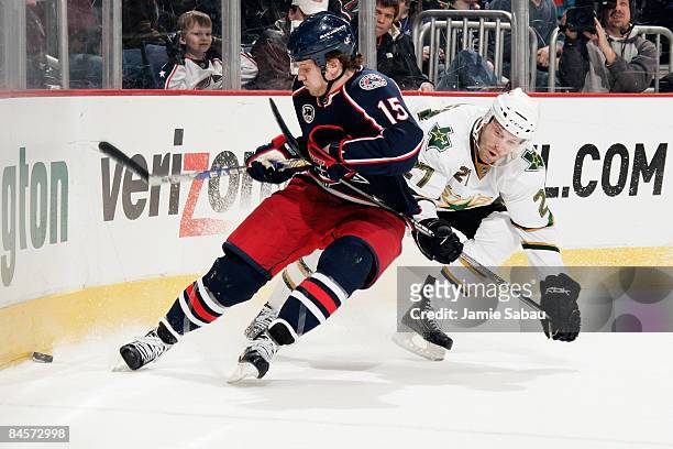 Derek Dorsett of the Columbus Blue Jackets and Andrew Hutchinson of the Dallas Stars chase down a loose puck into the corner during the first period...