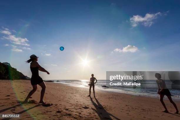 happy family playing volleyball at the beach - girls beach volleyball stock pictures, royalty-free photos & images