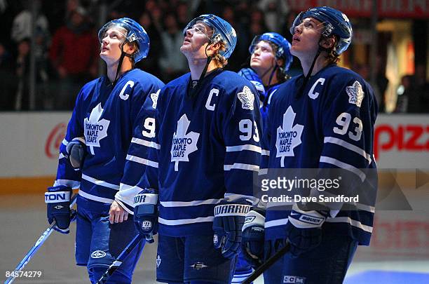 Anton Stralman,Matt Stajan, Mikhail Grabovski and Luke Schenn of the Toronto Maple Leafs look on as Doug Gilmour's is raised to the rafters prior to...