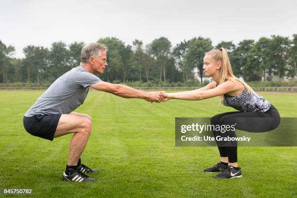 Duelmen, Germany Leisure sports and personal fitness. Father and daughter make squats on a sports field. Staged picture on August 10, 2017 in...