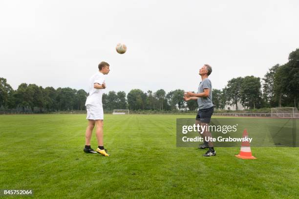 Duelmen, Germany Leisure sports, training on a sports field. A man and a teenager are practicing headballs. Staged picture on August 10, 2017 in...
