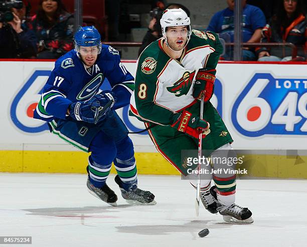 Brent Burns of the Minnesota Wild skates the puck away from Ryan Kesler of the Vancouver Canucks during their game at General Motors Place on January...