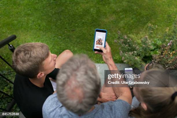 Duelmen, Germany Two teenagers and their father are busy with their smartphones. Staged picture on August 10, 2017 in Duelmen, Germany.