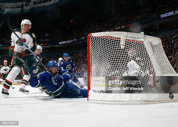 Martin Skoula of the Minnesota Wild looks on as Ryan Kesler of the Vancouver Canucks scores on goaltender Niklas Backstrom of the Minnesota Wild...