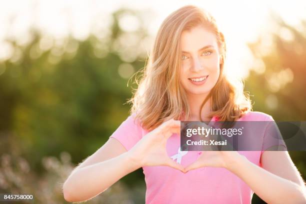 smiling woman with ribon for prevention breast cancer - prevent illness stock pictures, royalty-free photos & images
