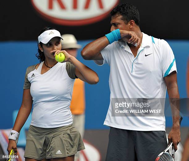 Sania Mirza and Mahesh Bhupathi of India communicate during their game against Andy Ram of Israel and Nathalie Dechy of France in the mixed doubles...