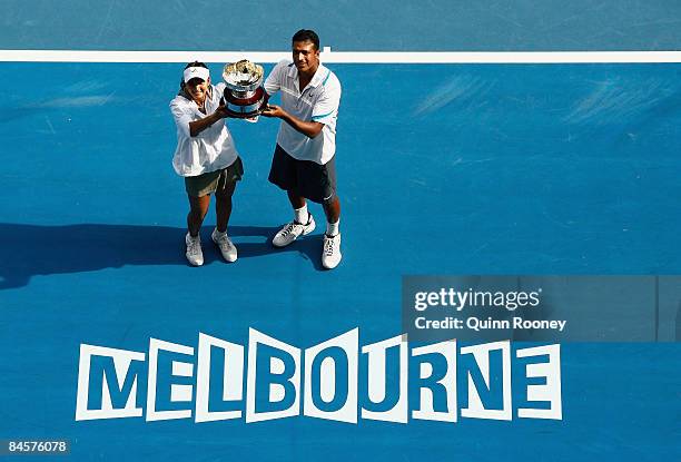 Sania Mirza and Mahesh Bhupathi of India pose with the championship trophy after winning their mixed doubles final match against Nathalie Dechy of...