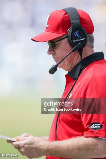 Louisville Cardinals head coach Bobby Petrino looks at the playbook during a college football game between the Louisville Cardinals and the North...