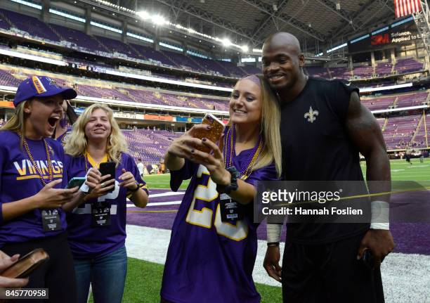 Adrian Peterson of the New Orleans Saints signs autographs and takes pictures with fans before the game against the Minnesota Vikings on September...