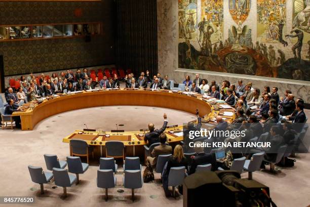 Members of the UN Security Council vote at a UN Security Council meeting over North Korea's new sanctions on September 11, 2017 at the UN...