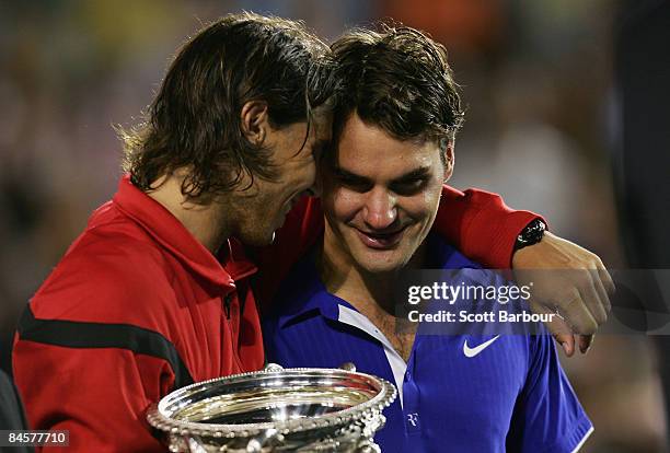 Rafael Nadal of Spain consoles Roger Federer of Switzerland during the trophy presentation after his men's final match during day fourteen of the...