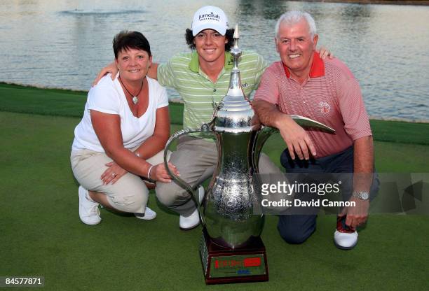 Rory McIlroy of Northern Ireland poses with the trophy alongside his parents Rosie and Gerry after winning the 2009 Dubai Desert Classic on the...