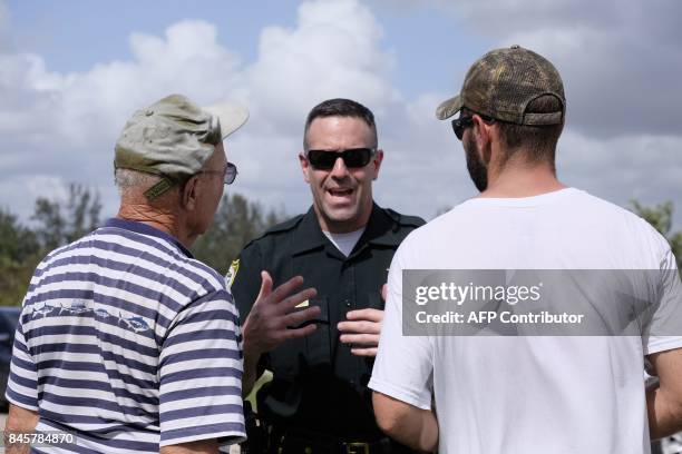 Monroe County Deputy Sherrif J. Pettorini speaks to two Keys resident a who are prevented from returing to their homes following Hurricane Irma on...