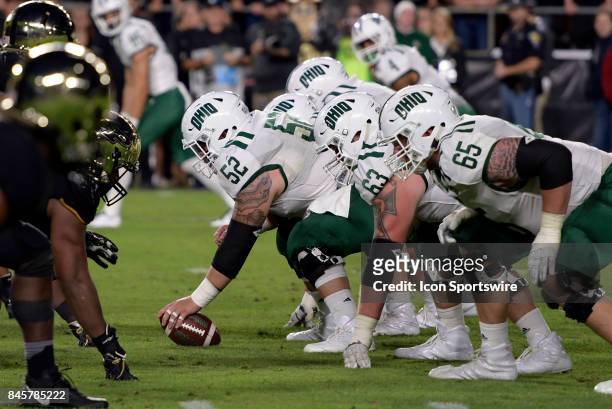 Ohio Bobcats offensive lineman Jake Pruehs and the offensive line prepare for snapping the ball during the college football game between the Ohio...