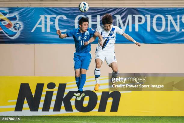 Guangzhou R&F defender Jiang Zhipeng fights for the ball with Gamba Osaka defender Yonekura Koki during the 2015 AFC Champions League Group Stage F...