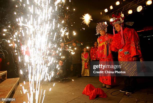 People dressed in traditional costumes of Tang nationality perform a Tang-style wedding ceremony for tourists at the Small Wild Goose Pagoda, the...