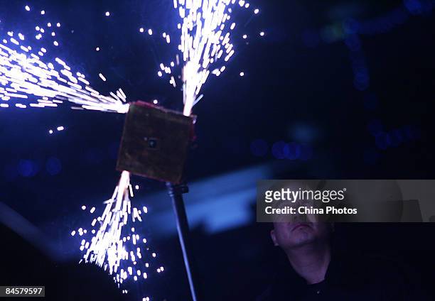Worker checks firework before a Tang-style wedding ceremony for tourists at the Small Wild Goose Pagoda, the symbol of the old-line Xian on February...