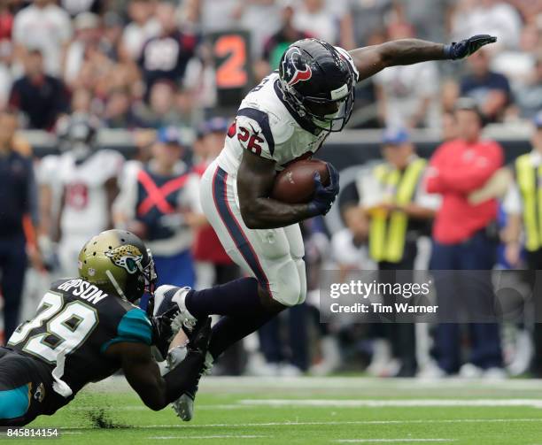 Lamar Miller of the Houston Texans is tripped up by Tashaun Gipson of the Jacksonville Jaguars in the fourth quarter at NRG Stadium on September 10,...