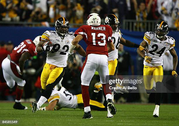 James Harrison of the Pittsburgh Steelers runs back an interception for 100 yards to score a touchdown in the second quarter against Kurt Warner of...