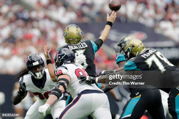 Blake Bortles of the Jacksonville Jaguars throws a pass under pressure by Jadeveon Clowney and J.J. Watt of the Houston Texans in the first quarter...