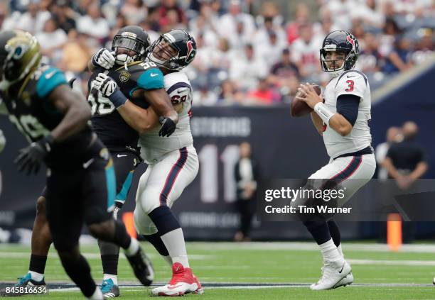 Tom Savage of the Houston Texans looks to pass as Breno Giacomini blocks Dante Fowler of the Jacksonville Jaguars in the first quarter at NRG Stadium...