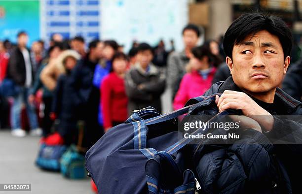 Migrant workers arrive at the West Railway Station with their luggage on February 2, 2009 in Beijing, China. After Chinese New Year holiday,...