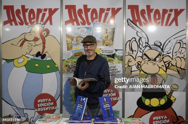 French comic writer, designer and colourist Jean-Yves Ferri poses next to banners depicting Asterix and Obelix during the International Comic...