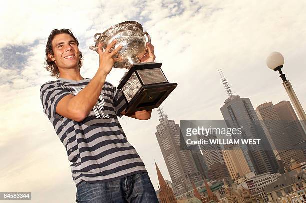 Rafael Nadal of Spain holds the Australian Open tennis trophy for photographers a day after defeating Roger Federer of Spain in the final, in...