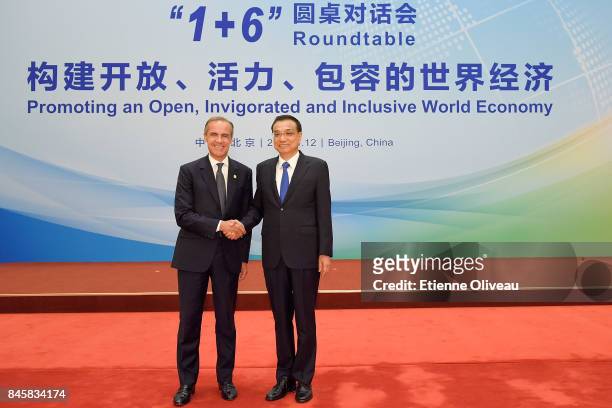 Chairman Mark Carney of the G20's Financial Stability Board shakes hands with Chinese Premier Li Keqiang before The 1+6 Round Table Dialogue meeting...