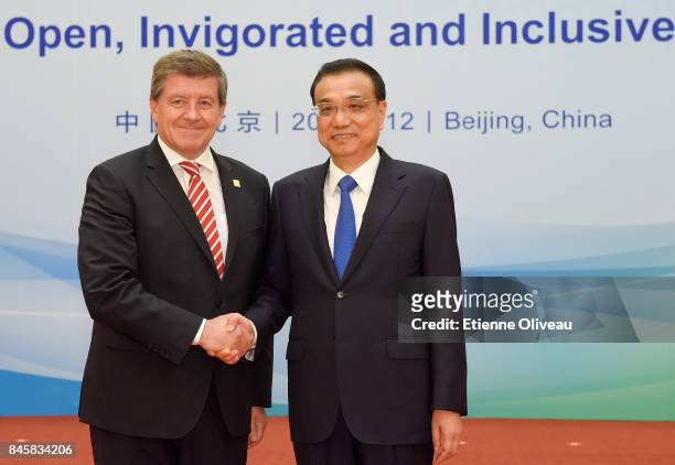 Director-General Guy Ryder of the International Labor Organization shakes hands with Chinese Premier Li Keqiang before The 1+6 Round Table Dialogue...