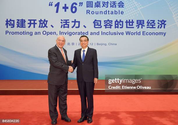 Secretary-General Angel Gurra of the Organization for Economic Cooperation and Development shakes hands with Chinese Premier Li Keqiang before The...